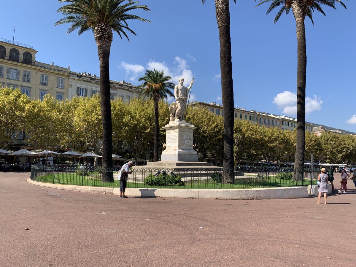 Bastia : statue de Napoléon sur la place Saint-Nicolas, palmiers et façades
