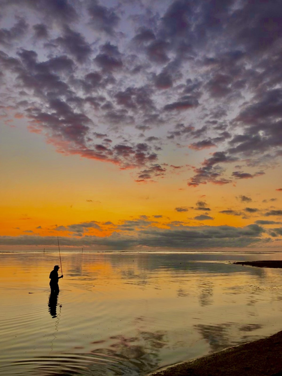 Pescador al atardecer en el lagoón de l’Hermitage, La Reunión