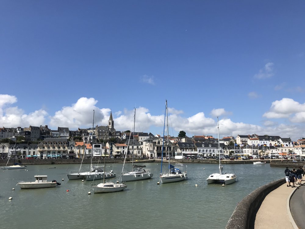 Hafen von Pornic mit festgemachten Segelbooten und Häusern an der Uferpromenade