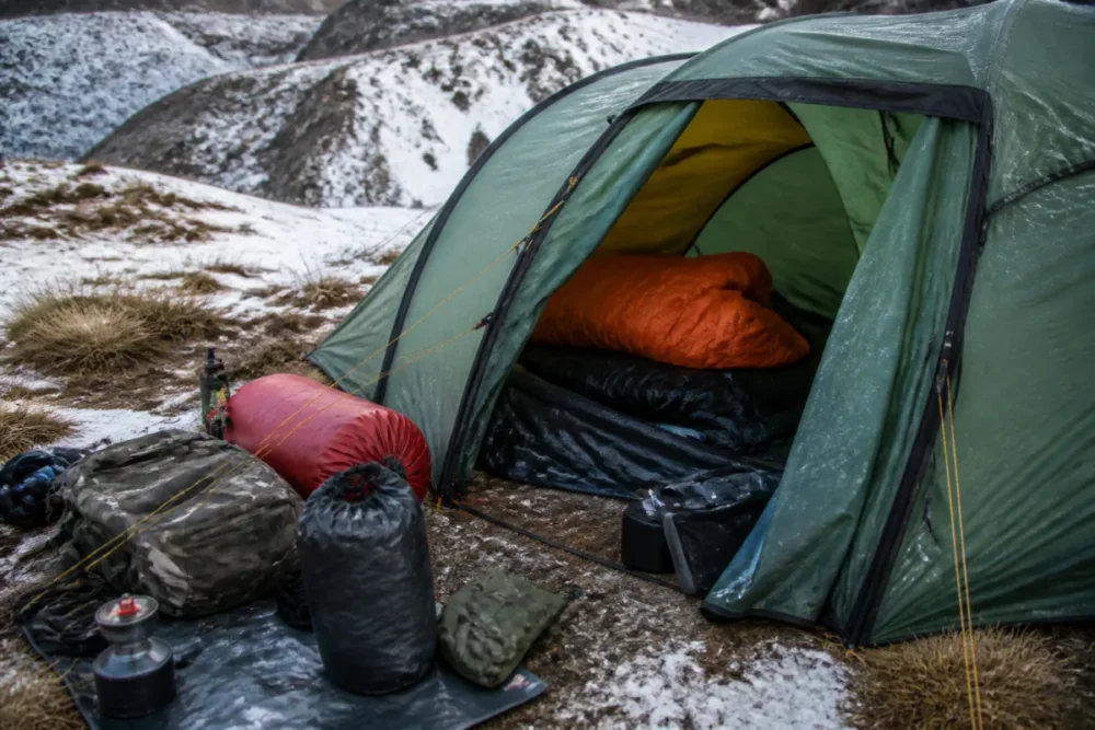 Campement d’hiver avec tente renforcée, matelas isolant et équipement de camping contre le froid