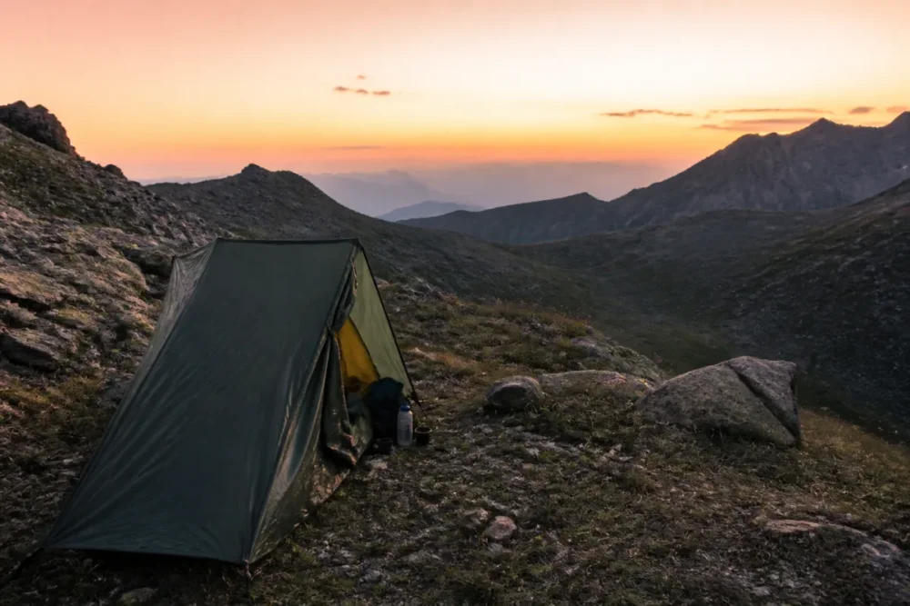 Bivouac en France avec tente légère de randonnée au coucher du soleil