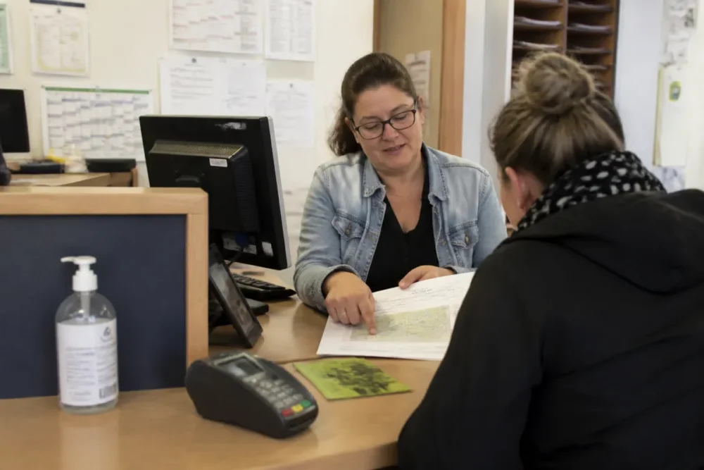 Parent au service scolaire de la mairie pour vérifier le rattachement à une école primaire