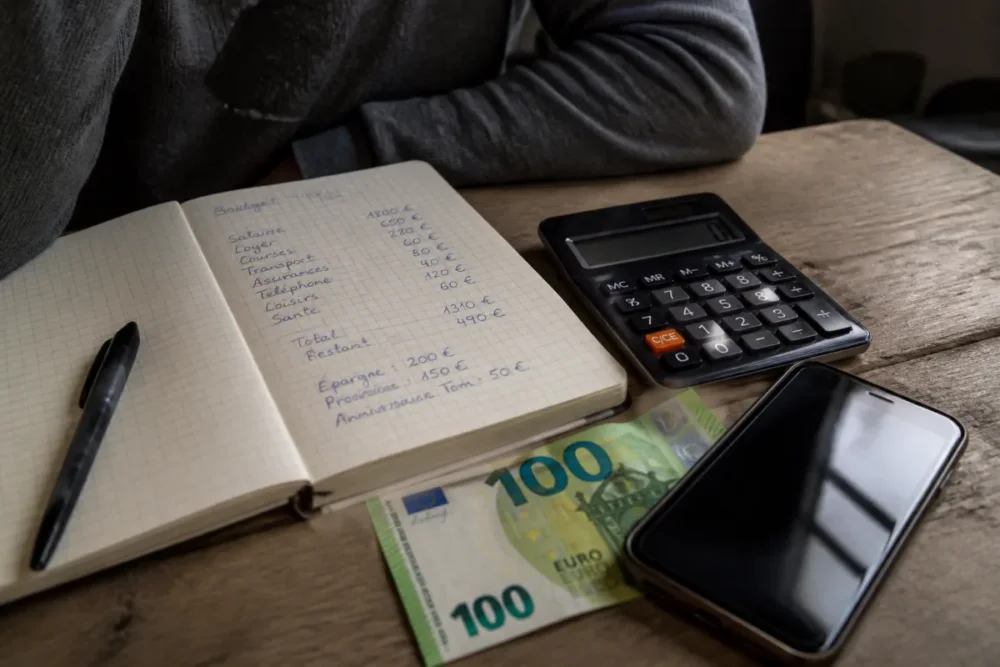 Carnet de budget et billet de 100 euros pour comparer les options d’investissement débutant