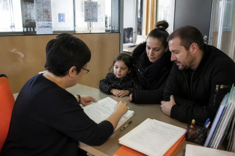 Famille préparant une inscription scolaire 2026 au guichet d’une mairie