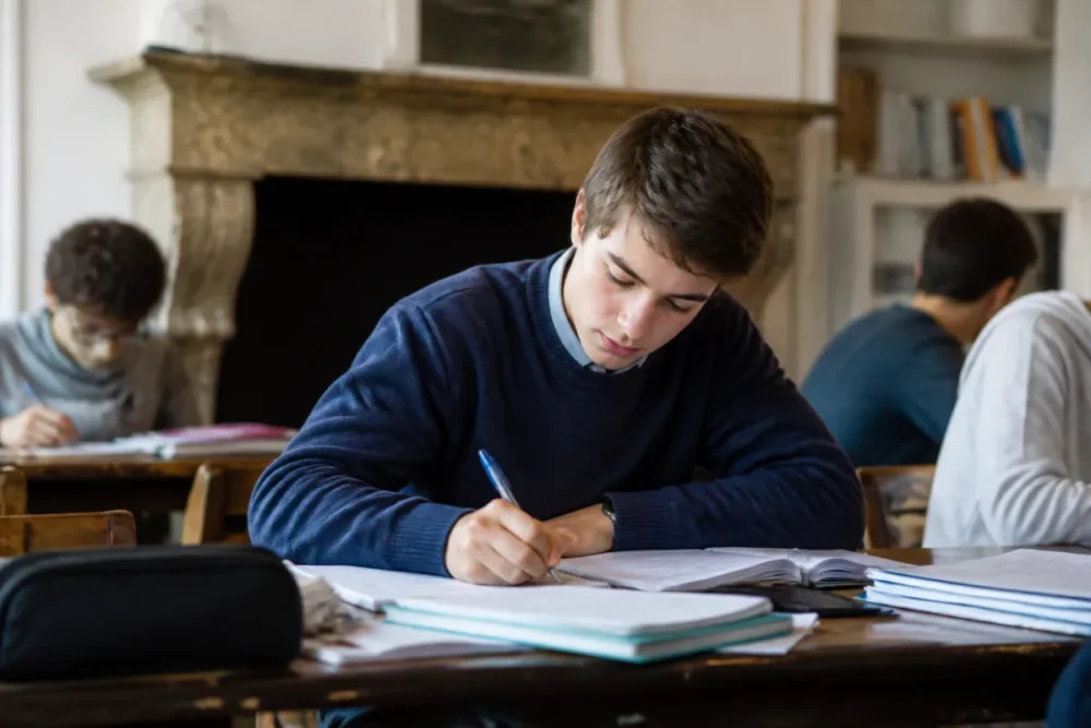 Realistic photo of a high school boarder in a collective study room