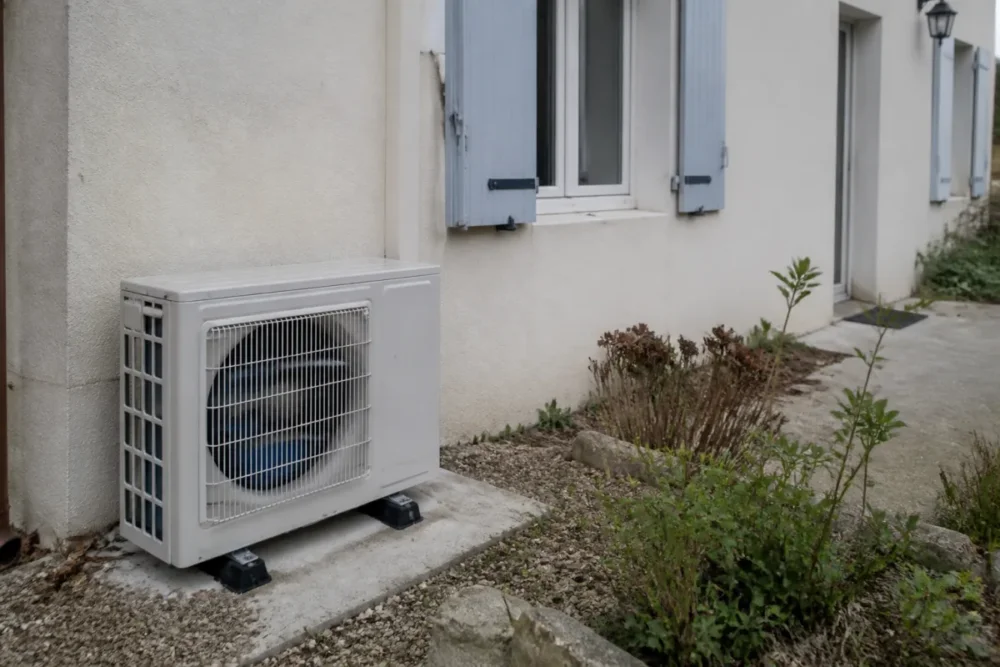Unité extérieure de pompe à chaleur air-air installée près d’une maison individuelle