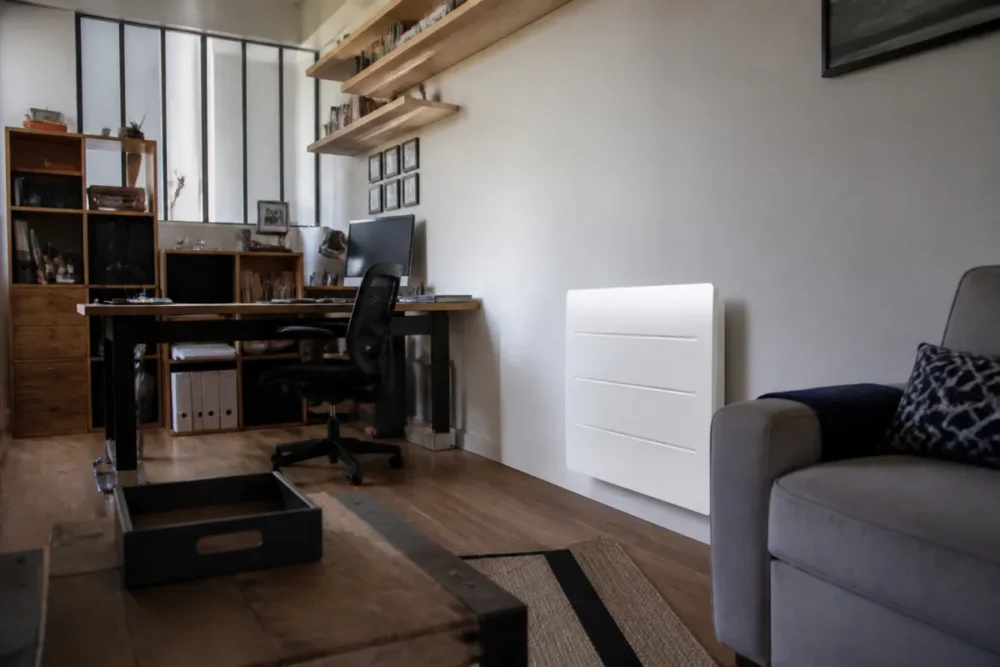 Photo réaliste d’une pièce de vie avec radiateur à inertie, adaptée à un usage prolongé comme un salon ou un bureau