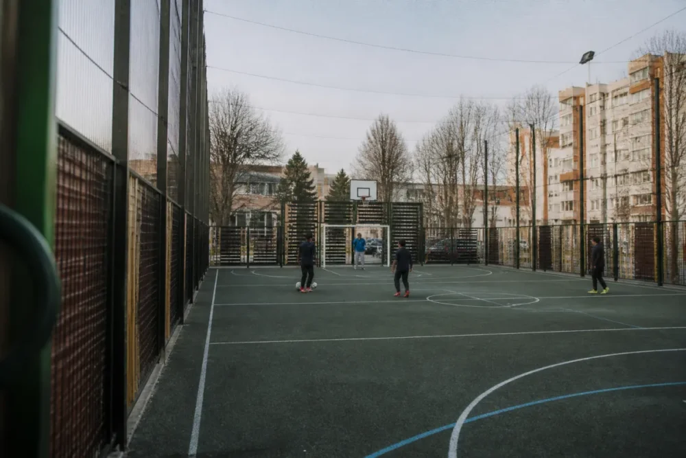 City stade extérieur avec clôture, buts et paniers de basket