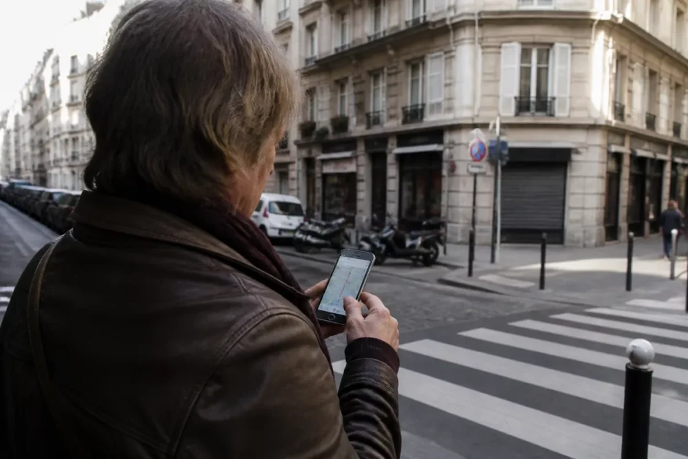 Realistic photo of a smartphone displaying the geolocation of a municipality within a city