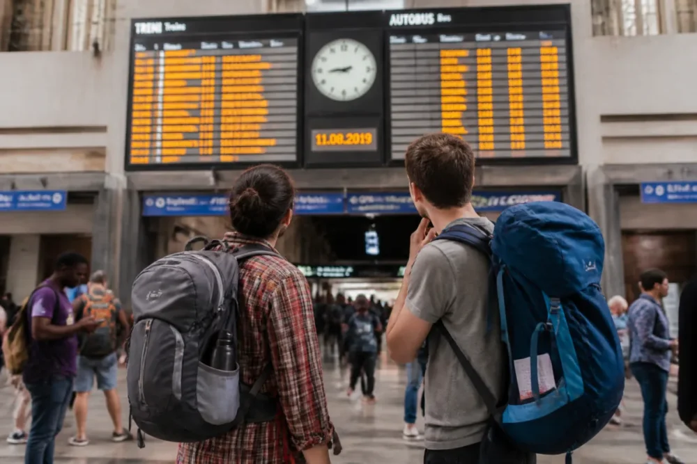 Voyageurs avec sacs à dos dans une gare européenne pour un transport low cost Europe