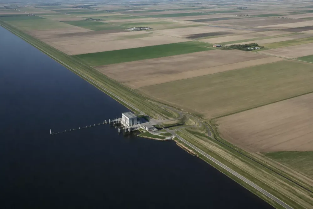 Vue aérienne d’un polder de Flevoland entre digue, canal et parcelles agricoles.