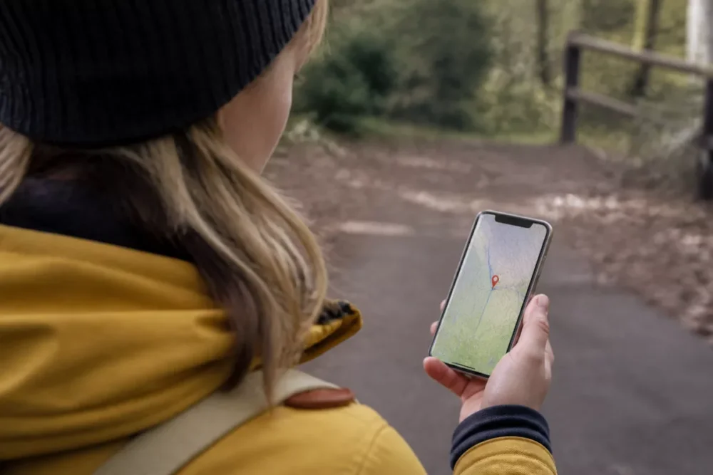 Photo réaliste d’une personne consultant une carte interactive avec des coordonnées GPS