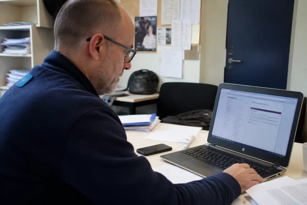 Photo réaliste d’un enseignant consultant son espace iProf Amiens sur ordinateur portable