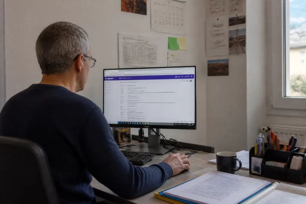 Enseignant utilisant iProf Grenoble sur ordinateur dans un bureau