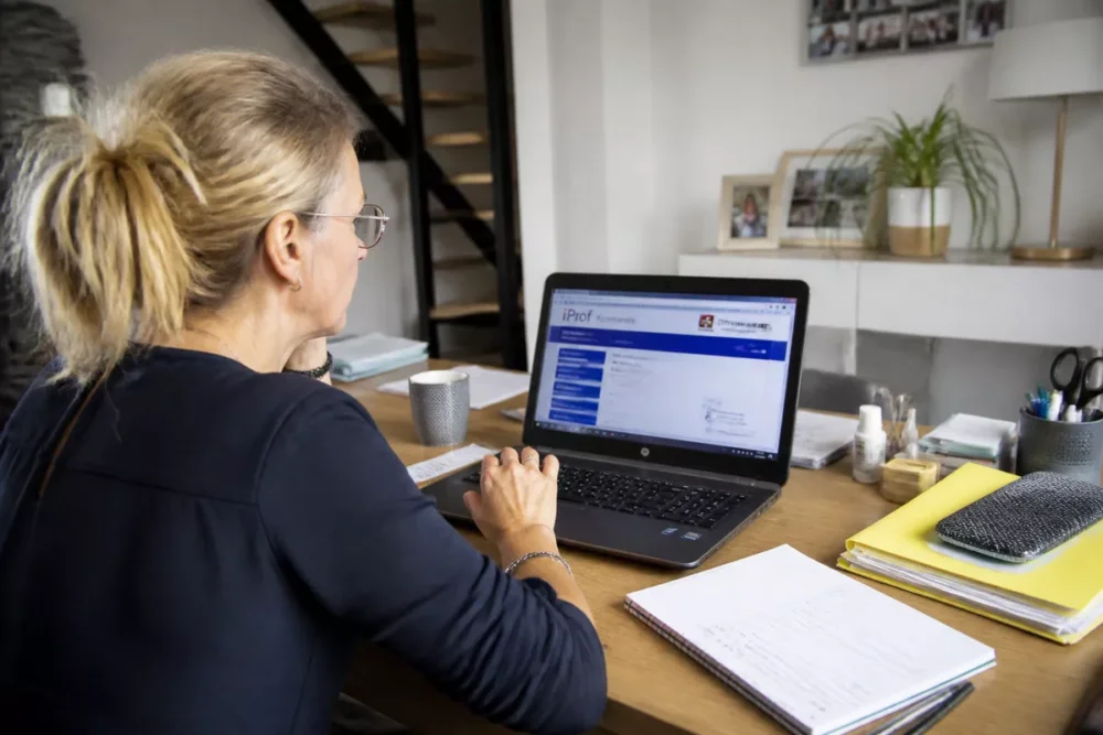 Photo réaliste d’un enseignant consultant son espace iProf Normandie sur ordinateur