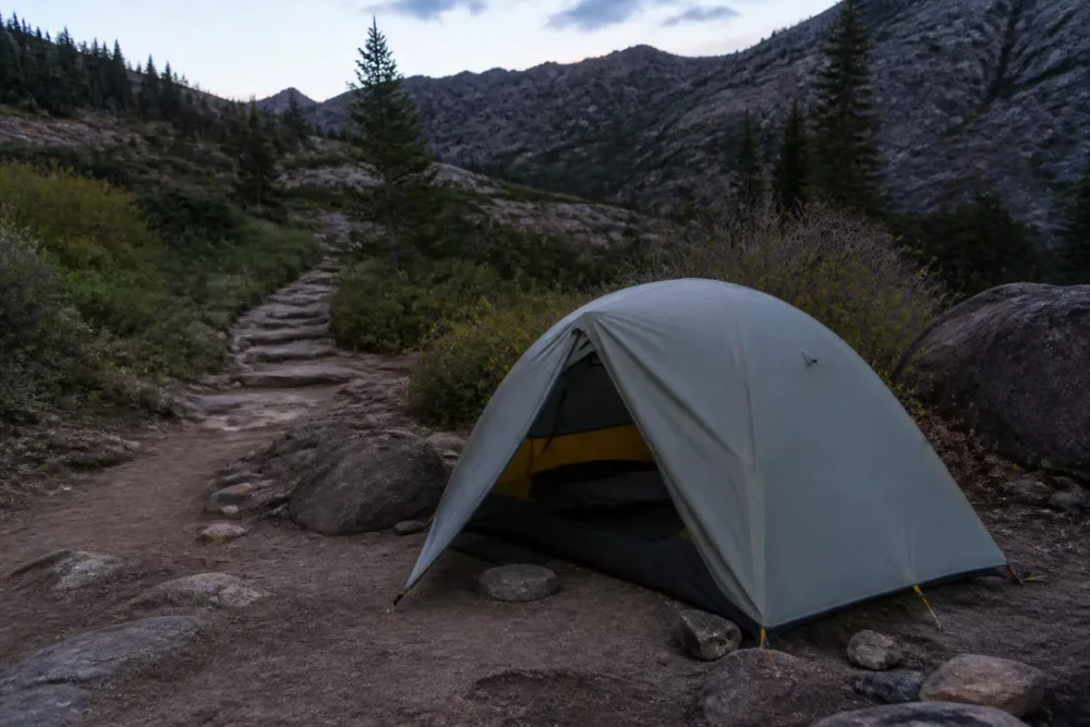 Tente légère installée au crépuscule dans un environnement naturel sans dégrader la végétation