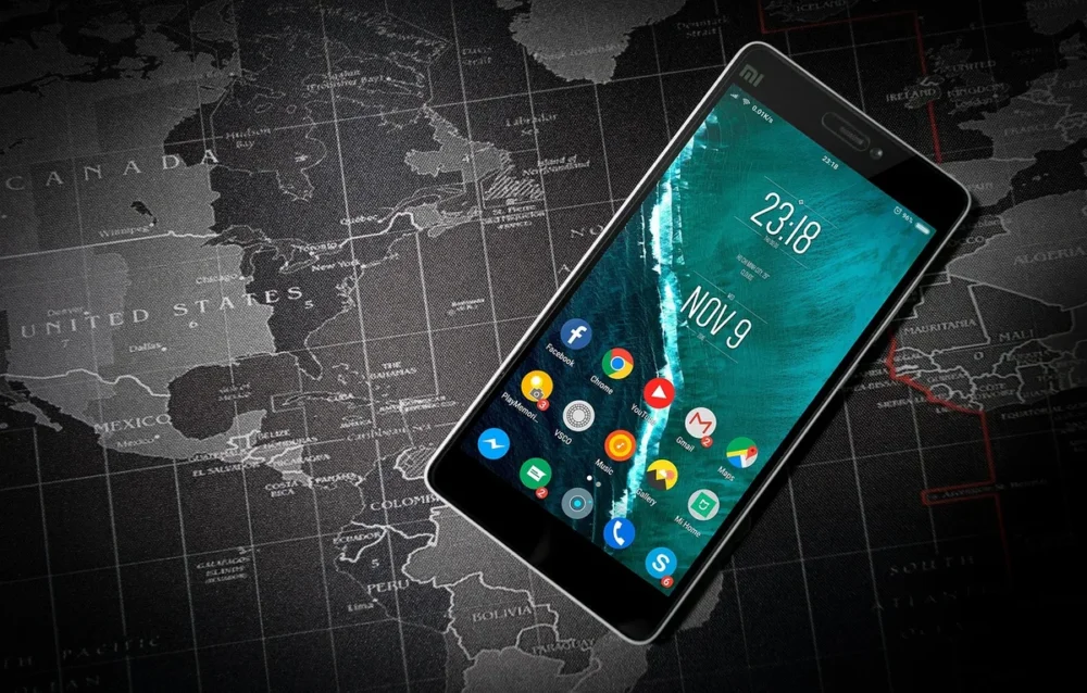 Smartphone affichant une carte du monde pour comprendre la couverture mobile en voyage